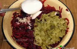 Чтобы приготовить  салат из свеклы с рыбными консервами, свеклу и огурцы трем на терке, чеснок пропускаем через пресс (или трем на мелкой терке). Добавляем  1 ст. лож. майонеза и перемешиваем.