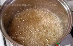 Для начала приготовим форму, в которую будем выливать готовый рахат-лукум: застилаем ее пищевой пленкой и смазываем маслом. Теперь варим сахарный сироп. В кастрюлю засыпаем сахар, воду и лимонную кислоту. Все перемешиваем, на среднем огне доводим до кипения и кипятим под крышкой 5 мин. Затем, помешивая, варим на среднем огне до золотистого цвета (7-15 мин) Накрываем крышкой и отставляем.