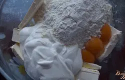 Для первого слоя пирога нужно смешать масло комнатной температуры, желтки, сметану, муку и соду гашенную лимонным соком или уксусом.