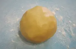 Сформовать из теста плотный шар и переложить на посыпанный мукой коврик.