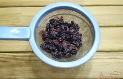  Запариваем кипятком изюм. Затем отцеживаем жидкость.
