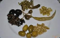 Мелко нарезать маринованные корнишоны и оливки