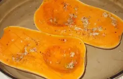 Я готовлю это блюдо с мускатной тыквой, вы можете использовать любую. Тыкву разрезать пополам вдоль и сделать надрезы по поверхности. Из оливкового масла, чеснока и  соли приготовим маринад и обмажем им тыкву сверху. Отправляем тыкву в духовку дял запекания на 30 минут при температре 170г С.