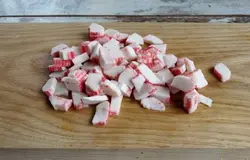Порежьте колечками крабовые палочки.
