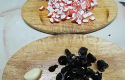 Для котлет нарезаю крабовые палочки, оливки и чеснок.