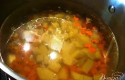 В воду кладем мелко порезанный картофель и морковь, варим 15 минут, посоли по вкусу