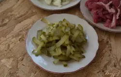 Соленые огурцы нарезать тонко соломкой. Можно взять 1 или несколько огурчиков в зависимости от его размера.
