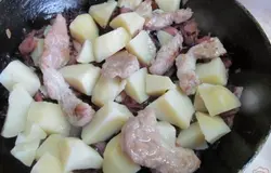 Выложить отваренную картофель без жидкости и сверху мясо. Влить молоко или половину стакана жидкости в которой варился картофель. Накрываем крышкой и тушим 15 минут после закипания.