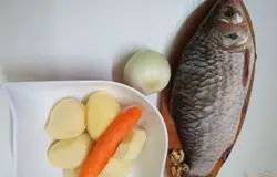 Для супа нам понадобится карась, картофель, морковь, лук. Карася чистим от чешуи, потрошим брюхо и тщательно моем под проточной водой.