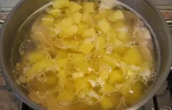 Картофель нарезать небольшими кубиками, добавить в сваренный бульон и варить 15 минут.