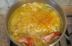 Копченое куриное крылышко промыть и разрезать на 2 части. Добавить в суп вермишель, крылышко и зажарку. Перемешать.
