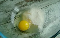 Поместите в миску куриное яйцо и сахар.