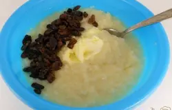 Изюм вымочить в горячей воде, обсушить и так же выложить в кашу. Добавить ваниль, молотую корицу и размягченное сливочное масло.