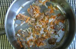 К мясу добавляем измельченный лук и морковь, обжариваем еще 5 минут.
