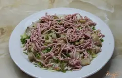 Далее грибы с зеленым луком, колбаса, снова майонез, морковь, яйца куриные смазываем майонезом, посыпаем консервированной кукурузой, русским сыром и смазываем последний раз майонезом. Сверху посыпаем помидором и зеленым луком.