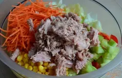 Добавить соломку из моркови, кукурузу  и тунец.