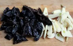 Чернослив нарезаем. Чеснок чистим и режем на кусочки.