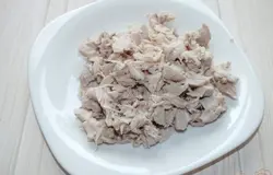Вынуть готовую курицу из бульона. Отделить мясо от костей и мелко нарезать