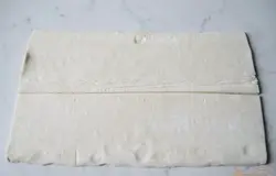 Слоеное тесто размораживаем. Разрезаем пополам.