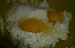 Затем добавляю к манке со сметаной яйца и сахар.