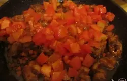С помидор снимаем кожицу, нарезаем на кубики и высыпаем к мясу.