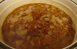 Перекладываем подливку с мясом в кастрюлю, заливаем 1,5 литрами кипятка, добавляем соль, перец и оставляем тушиться минут 20.
