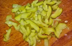 Соленый огурец нарежьте соломкой.
