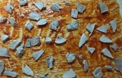 Отварите в соленой воде до готовности мясо. Нарежьте кусочками плоскими и разложите на корж равномерно.