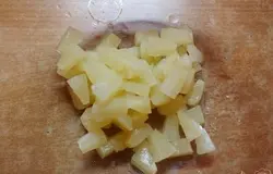 Ананас вынимаем из банки в сито. Даем стечь жидкости. Кладем в миску.
