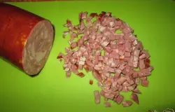 И также, как можно мельче, порезать колбасу, лучше копченую.