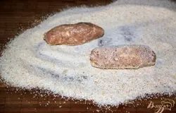На доску высыпать пан.сухари. Порционировать фарш с пом. ложки. Катать руками колбаски.