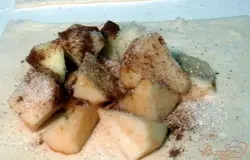 Каждый из кусочков теста раскатываем вдоль, а затем разрезаем на 2 квадрата. На каждый квадрат выкладываем яблоки, посыпаем их по своему вкусу сахаром и корицей.