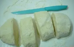 Замешиваем быстро тесто. Картофельное тесто не любит длительного вымешивания. Главное соединить компоненты. И ещё, это тесто липкое и требует постоянного подсыпания муки. Оно не должно быть тугим, но не должно быть жидким. Разрезаем тесто на 4 части, 3 убираем в холодильник, а с одной работаем.В холодильник ставим, чтобы тесто не разжижалось