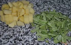 Очистить и нарезать картофель.Фасоль промыть, убрать хвостики и крупно нарезать.