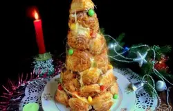 Готово! Осторожно снять бумажный конус и установить торт из профитролей на блюдо. Две вилки соединить спинками, окунуть в горячую карамель и разъединяя и соединяя вилки, вытянуть карамельные нити, обматывая ими крокенбуш. Дополнительно можно прикрепить на торт с помощью карамели разноцветные конфетки ММ. С Новым Годом и приятного аппетита!
