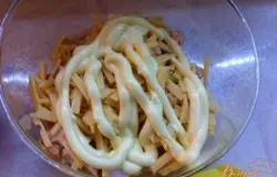 В салатни кладем курицу и сыр, добавляем майонез