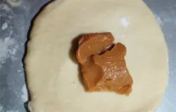 Каждый колобок раскатать в пласт, выложить начинку (вареное сгущенное молоко), сформировать булочку.