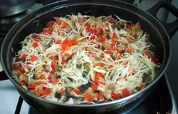 И сразу-же порезанную очень тонкой соломкой капусту. Закрываем крышкой и пассеруем на небольшом огне.