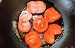 Сковородку смазываем растительным маслом и раскладываем кружочки помидоров.