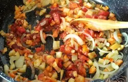 С помидор снять шкурку и нарезать кубиками. Добавить в сковороду вместе с томатной пастой и сахаром. Посолить и поперчить. Тушить 4 минуты, затем снять с огня.