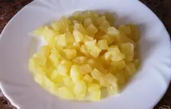 Слить сироп с ананасов и порезать кубиками.