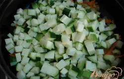 К луку и моркови добавляем цуккини, который предварительно нарезаем мелкими кубиками. Пассируем вместе на небольшом огне.