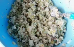 В миске смешать отварной рис, огурцы, яйца, шпроты, добавить зелёный горошек без жидкости, перемешать и заправить майонезом.