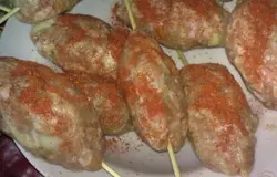 Мокрыми руками скатать из полученной массы небольшие колбаски. Нанизать их по одной на деревянные шпажки или шампуры. Смазать с помощью кисточки оливковым маслом, посыпать паприкой.