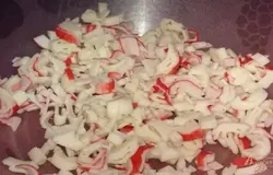 Крабовые палочки выньте из целлофановой обертки и натрите на крупной терке или нарежьте соломкой. Крабовые палочки можно заменить крабовым мясом.