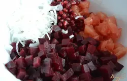 В салатник уложить кубики отварной свеклы, зерна граната, кусочки грейпфрута, полукольца молодого лука