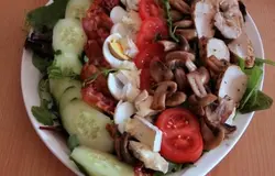 Сверху на салат выложить рядами: огурец, бекон, яйца, кусочки сыра, помидор, грибы, ломтики куриного филе.