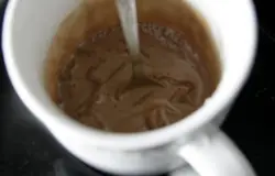 Поместить чашку в сотейник с горячей водой.Пластинки желатина отжать, ввести в капуччино, чтобы желатин разошёлся. Добавить  450 г сахара и ромовую эссенцию. Постоянно помешивать!