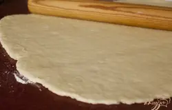 Припылить стол мукой, раскатать тесто в прямоугольный пласт не толще 1 см.