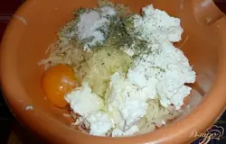 После этого к натертому картофелю добавляем куриное яйцо (если мелкие, то пару яиц), творог (любой, какой есть в наличии - жирность не важна), соль и любые специи или сушеные травы по вкусу. Если есть возможность, хорошо добавить свежую зелень (зеленый лук, укроп - по вашему вкусу), предварительно её измельчив.
